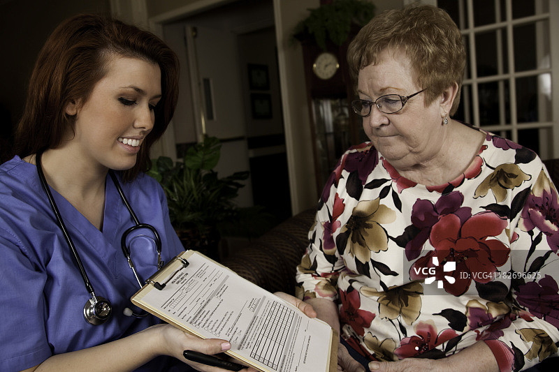 家庭保健专业人员帮助病人填写保险表格图片素材