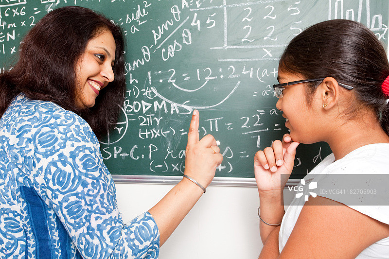 年轻的印度教师向她的学生解释数学问题图片素材
