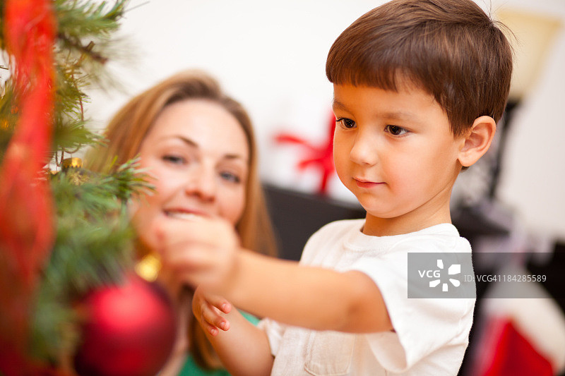 小男孩和妈妈一起装饰圣诞树图片素材