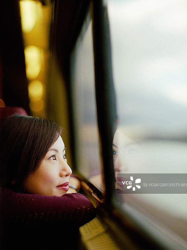 年轻女子望着火车窗外，特写，侧视图图片素材