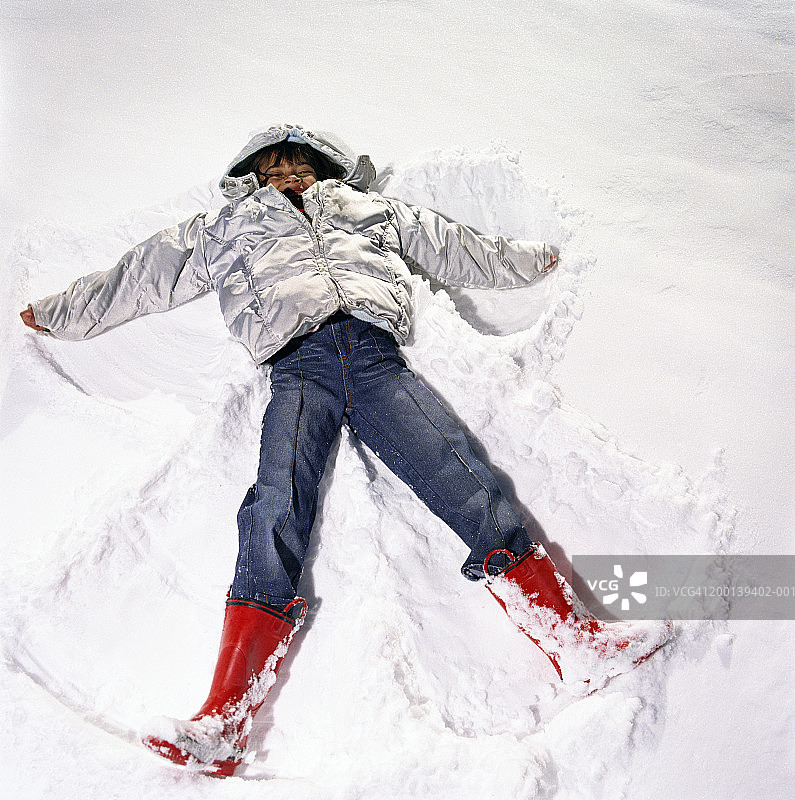 女孩(5-7)做雪天使，高视阔步图片素材