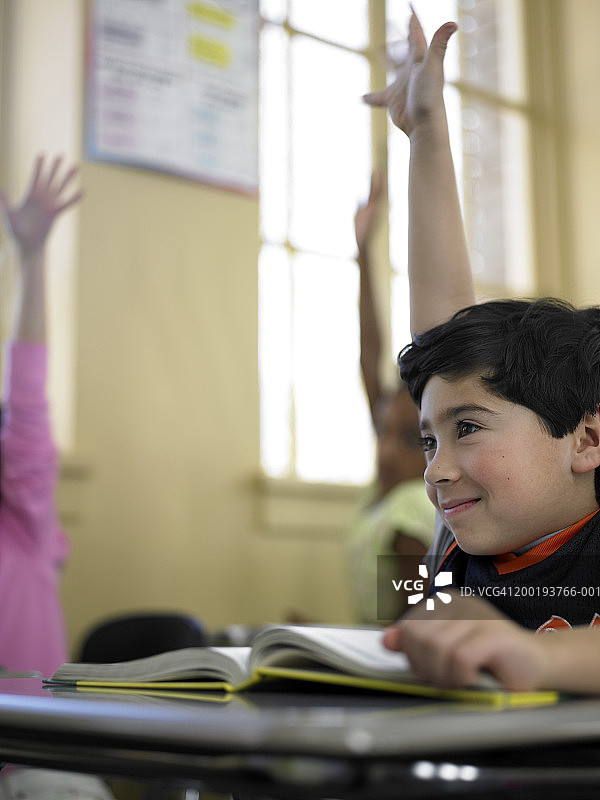 男孩(7-9)在课堂上举手图片素材