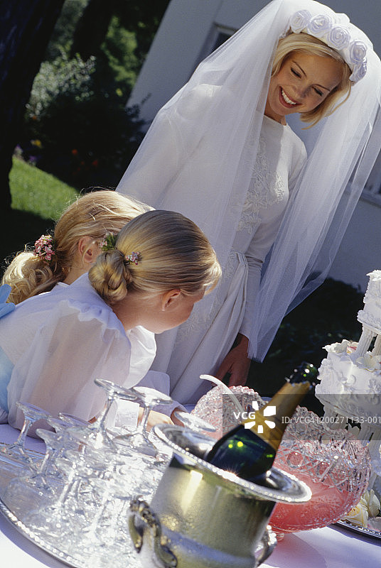 新娘和花童(4-5)(6-7)站在户外的桌子旁图片素材