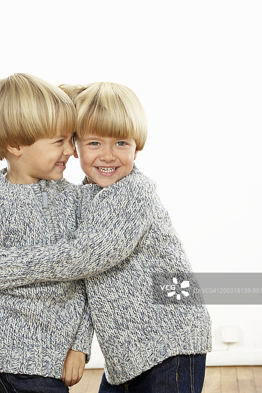 男孩(3-5)拥抱双胞胎兄弟，微笑，肖像图片素材
