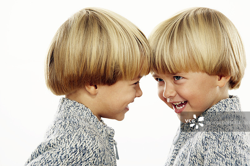 双胞胎男孩(3-5)头对头，微笑，一个侧面，特写图片素材