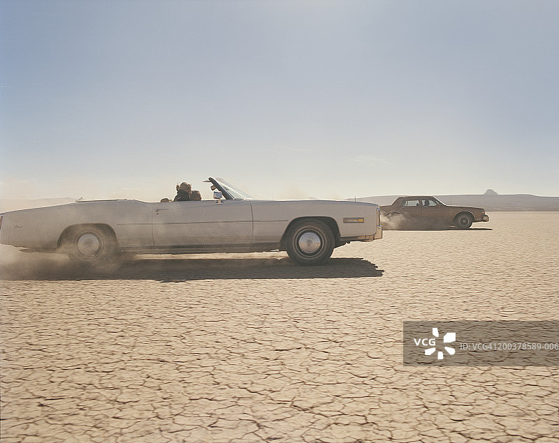 两辆车在沙漠里飙车，侧视图图片素材