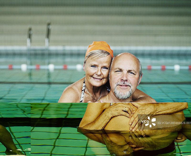 成熟的夫妇在游泳池拥抱，微笑，肖像图片素材