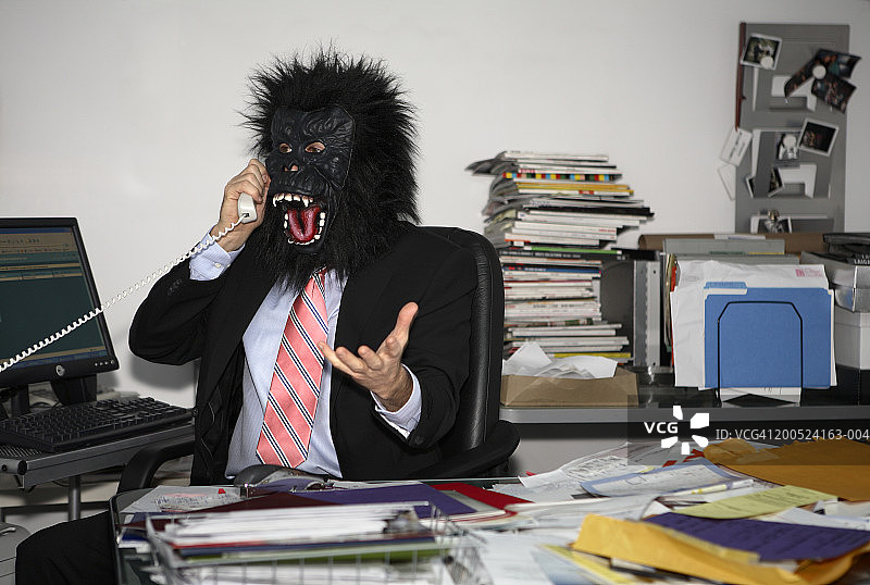 办公室里戴着大猩猩面具的男人图片素材