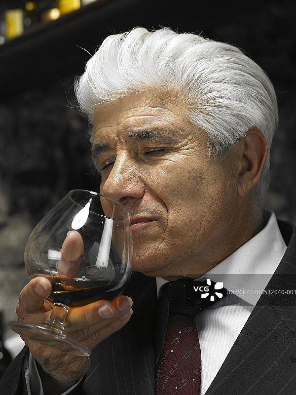 高级男子闻着红酒的香味，特写图片素材