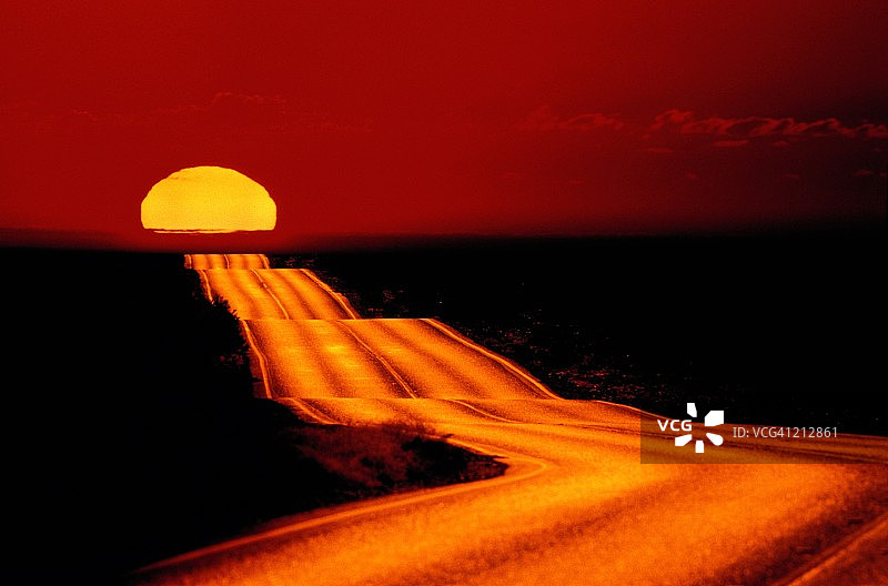 多山的沙漠路反射着夕阳图片素材