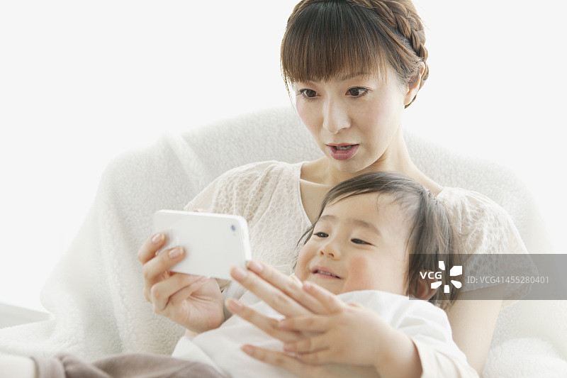 婴儿和母亲使用智能手机图片素材