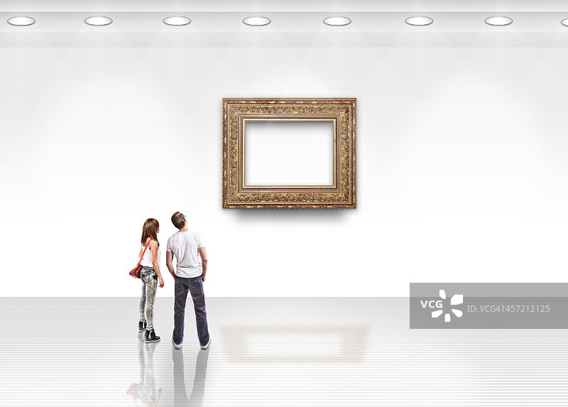 一对夫妇在看带金框的空白艺术品图片素材