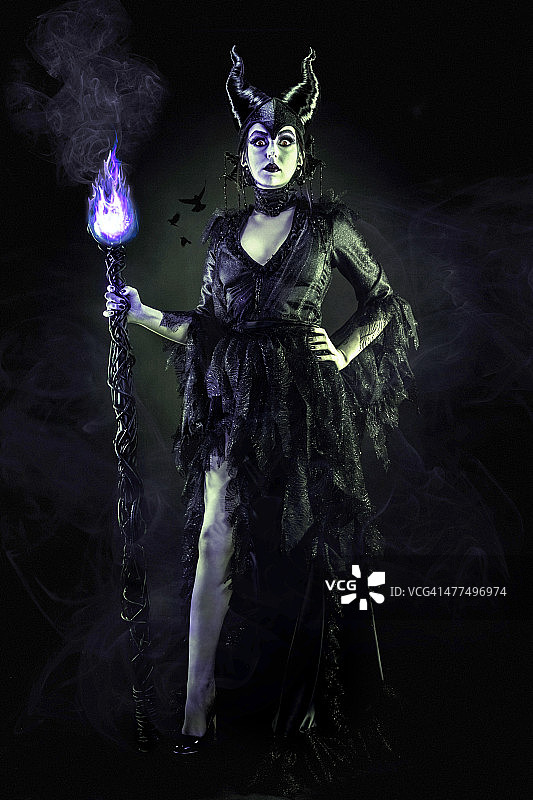 穿着黑长袍和魔法杖的邪恶女巫图片素材