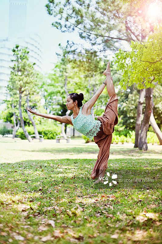 年轻的亚洲女子在东京公园练习瑜伽。图片素材