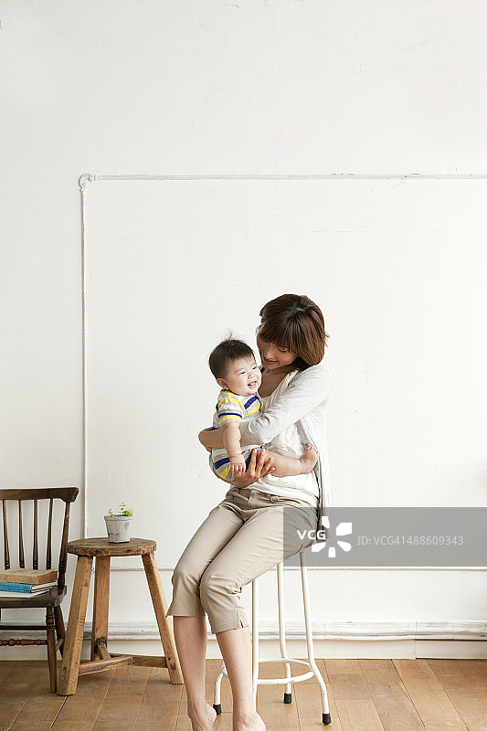母亲和婴儿坐在椅子上图片素材