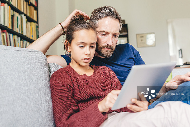慈爱的父亲和女儿使用数码平板电脑图片素材