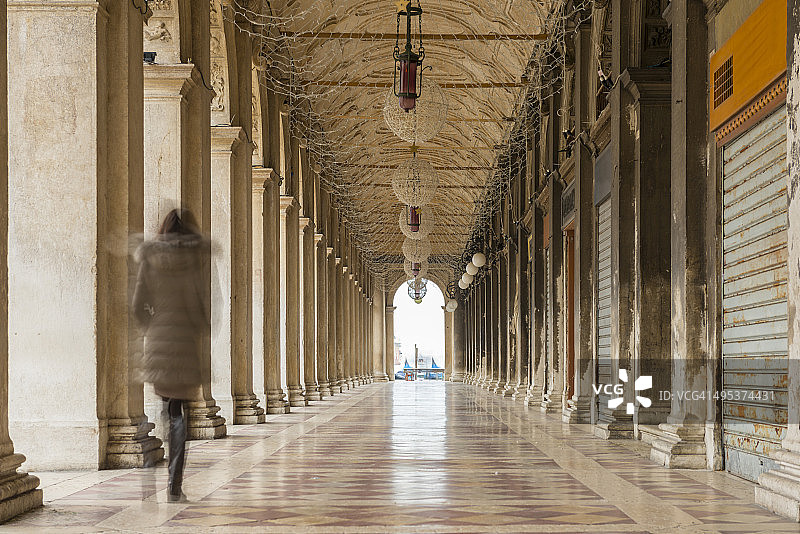 一个女人走在拱廊里图片素材
