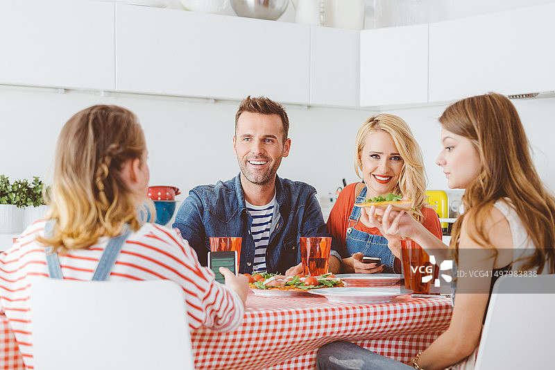 幸福的家庭在家里吃披萨午餐图片素材