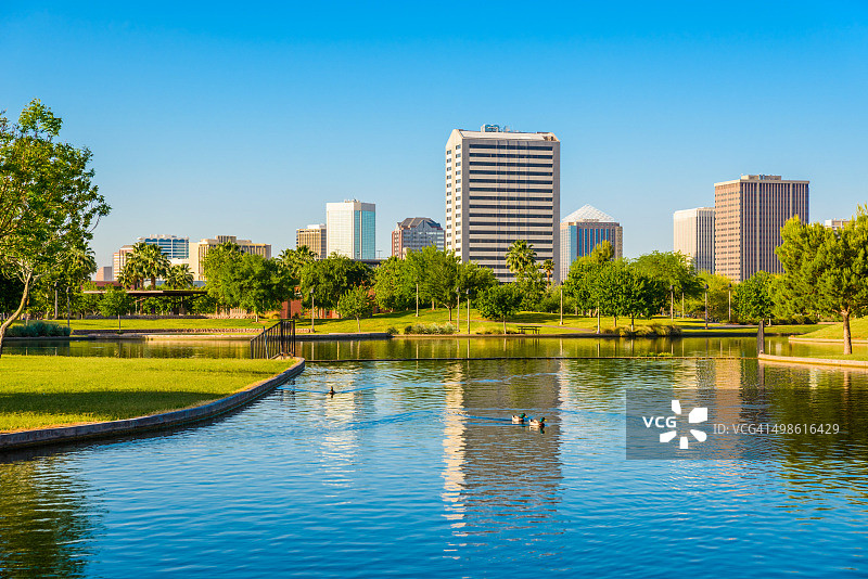 凤凰城亚利桑那天际线-公园，池塘，和摩天大楼的城市景观背景图片素材