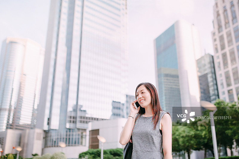 亚洲女性高管在城市中使用智能手机图片素材