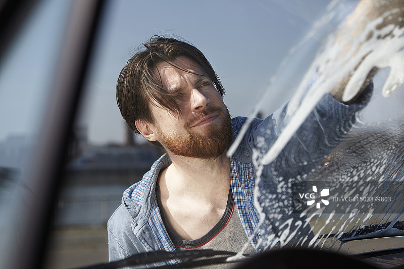 一名男子正在清洗一辆汽车的前窗图片素材