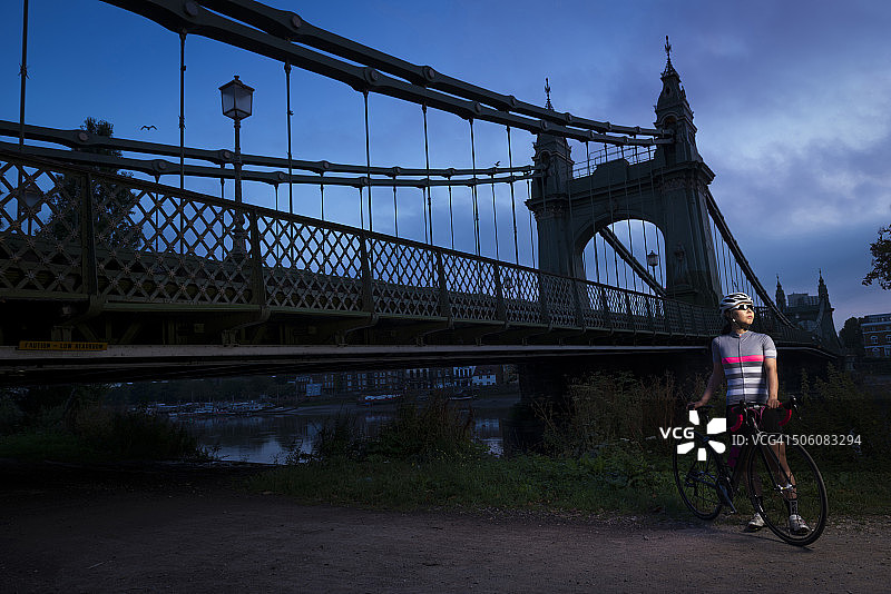黎明时分，在汉默史密斯桥，一名女子骑着一辆赛车图片素材