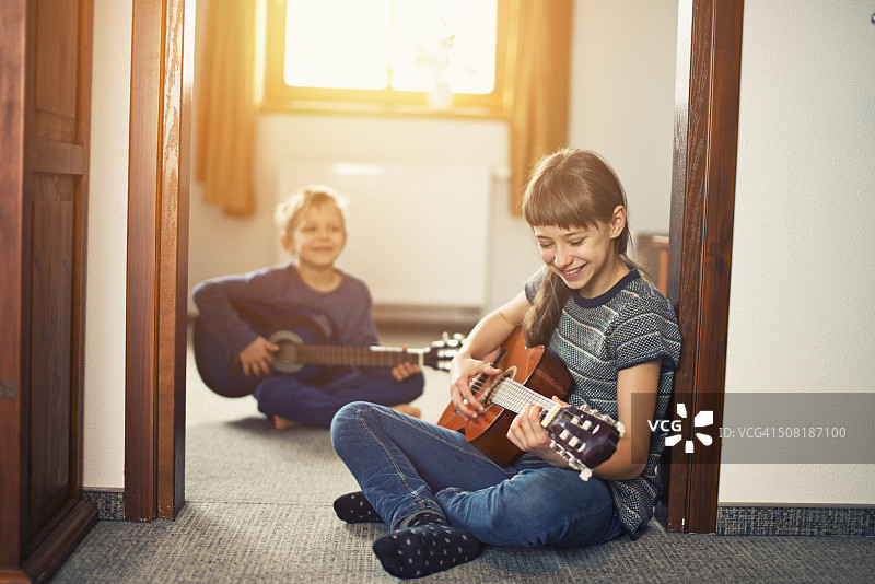 妹妹和弟弟玩吉他玩得很开心图片素材