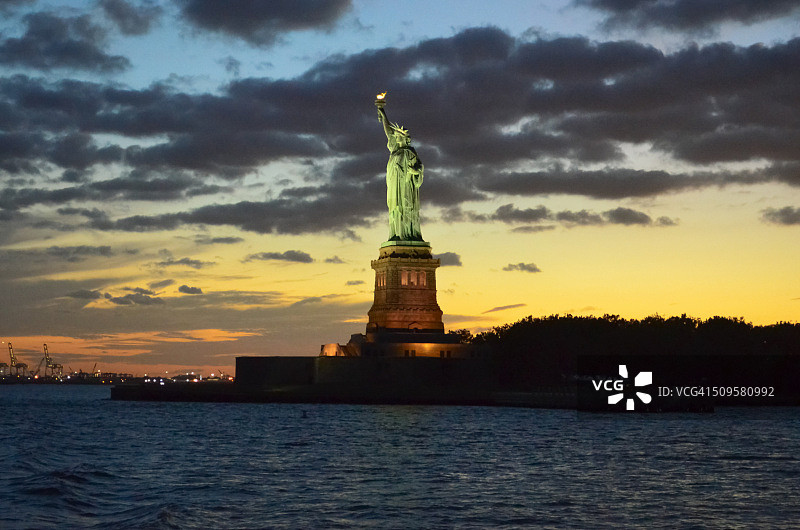 自由女神像在日落与戏剧性的天空，纽约，美国图片素材