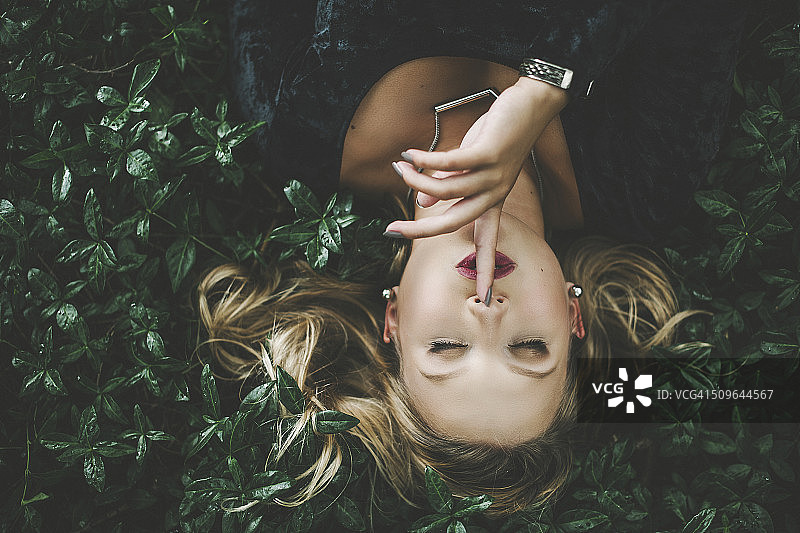 女人躺在绿色植物的户外图片素材