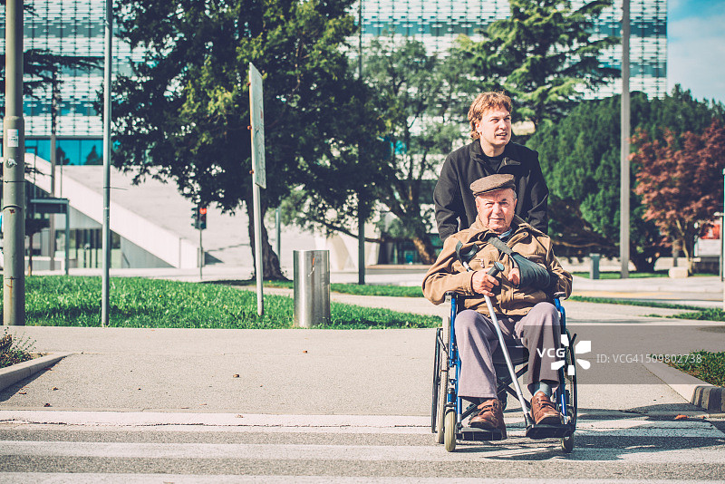 在轮椅上的老年残疾人和孙子在户外，欧洲图片素材