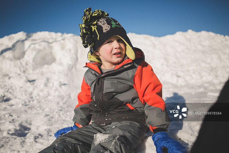 坐在雪地里的男孩图片素材