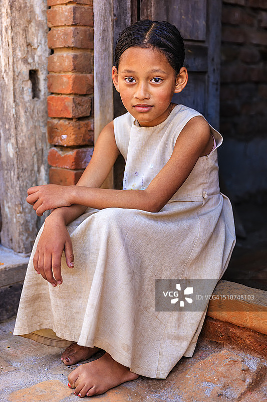 年轻的尼泊尔女孩坐在她的房子外面图片素材