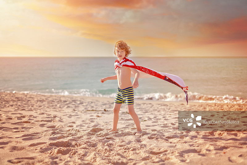 小男孩在沙滩上扮演超级英雄图片素材