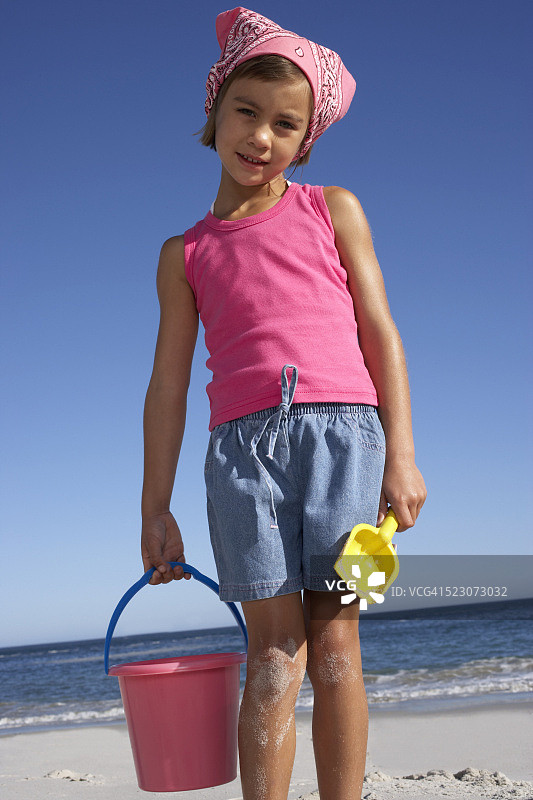 在海滩上拿着桶和铲子的女孩图片素材