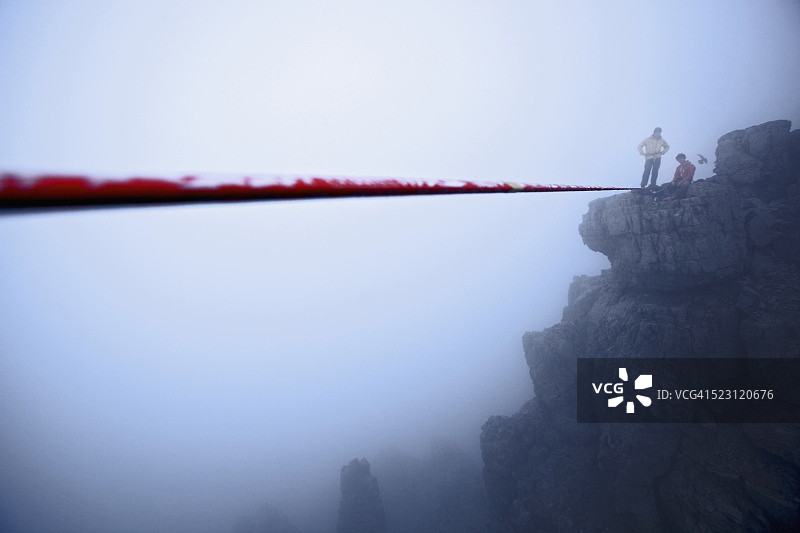 两名男子准备在奥地利泰洛山上的高绳上保持平衡图片素材