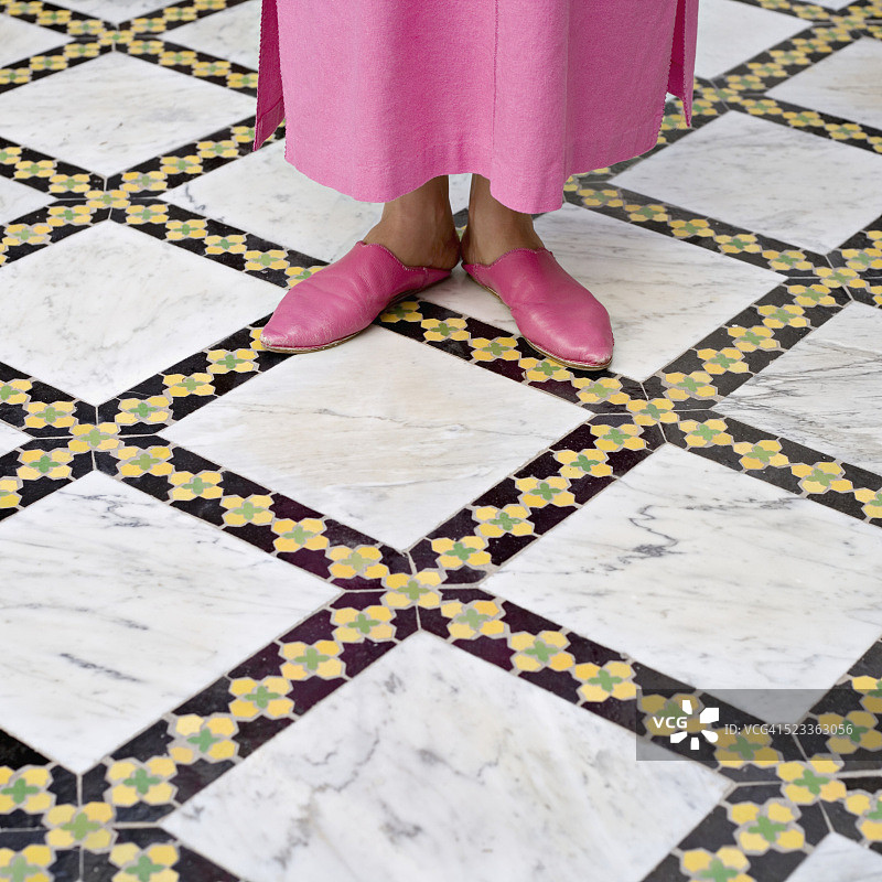 穿着摩洛哥拖鞋的女人站在马赛克地板上图片素材