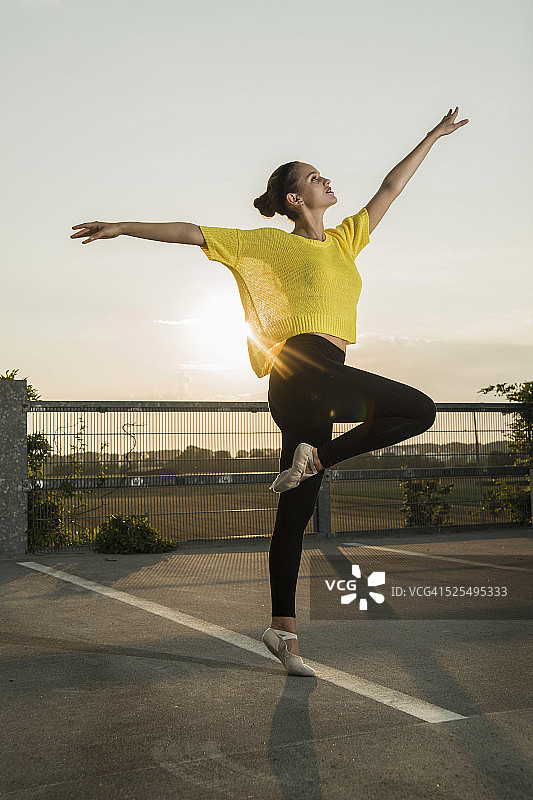 年轻的芭蕾舞演员在停车场锻炼图片素材