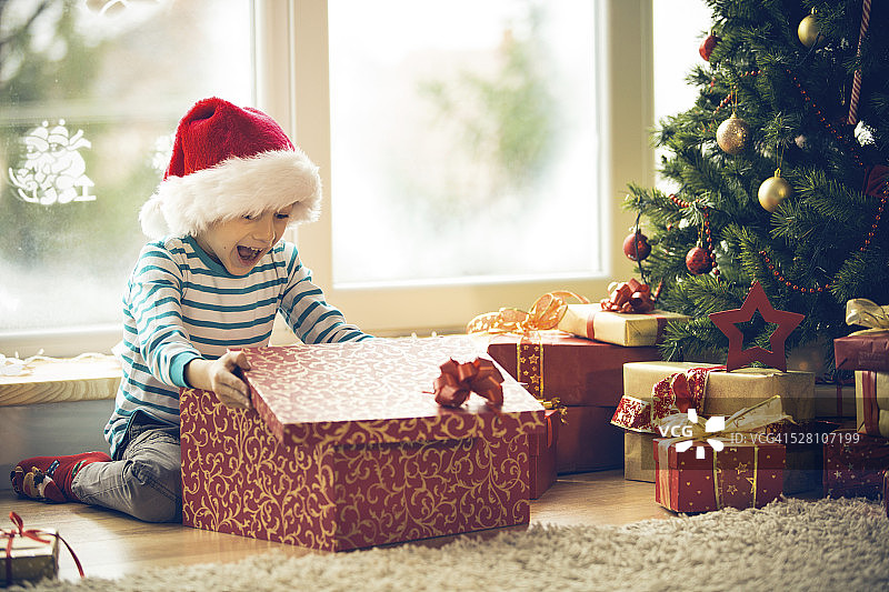 惊喜的小男孩打开圣诞礼物图片素材