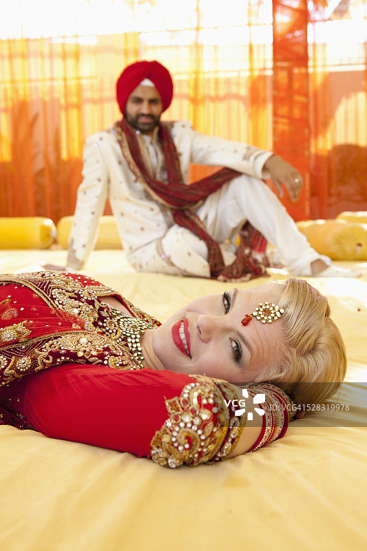 一个混血夫妇在他们的婚礼上穿着传统的印度服装参加婚礼的肖像;卢迪亚纳印度旁遮普图片素材