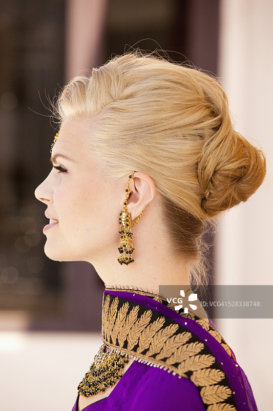 一个金发女人的侧面穿着紫色的纱丽和华丽的珠宝;卢迪亚纳印度旁遮普图片素材