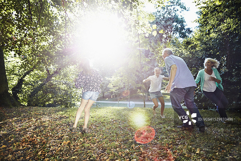 快乐的祖父母和孙女在公园里跑步图片素材