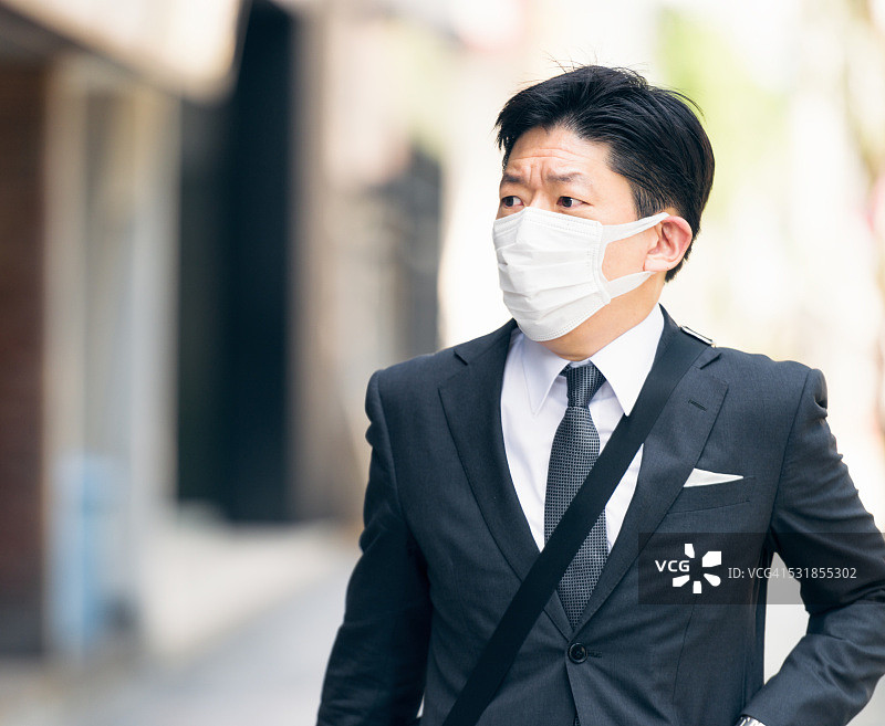 日本商人戴着口罩在东京街头图片素材