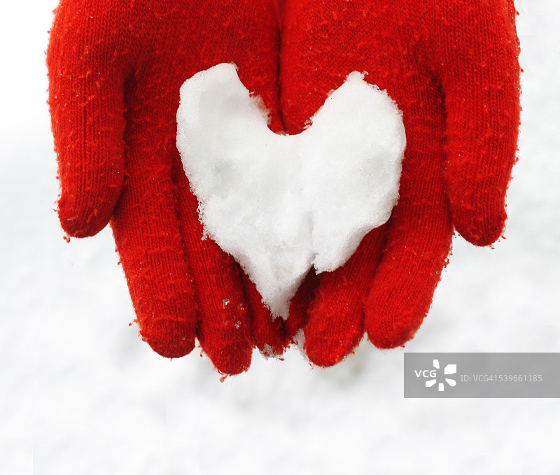 芬兰，近距离的女人抱着雪做的心图片素材