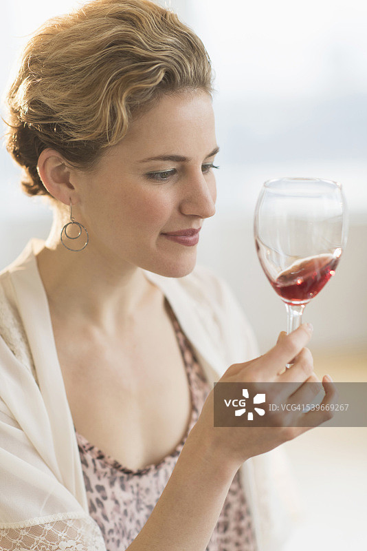 美国，新泽西州，年轻女子旋转红酒杯图片素材