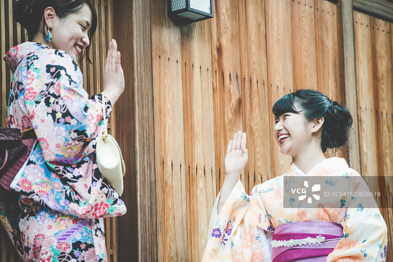 美丽的日本主人穿着和服迎接她的朋友，京都，日本图片素材