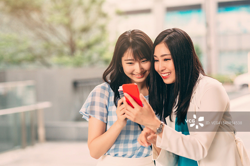 微笑的亚裔女孩发短信图片素材