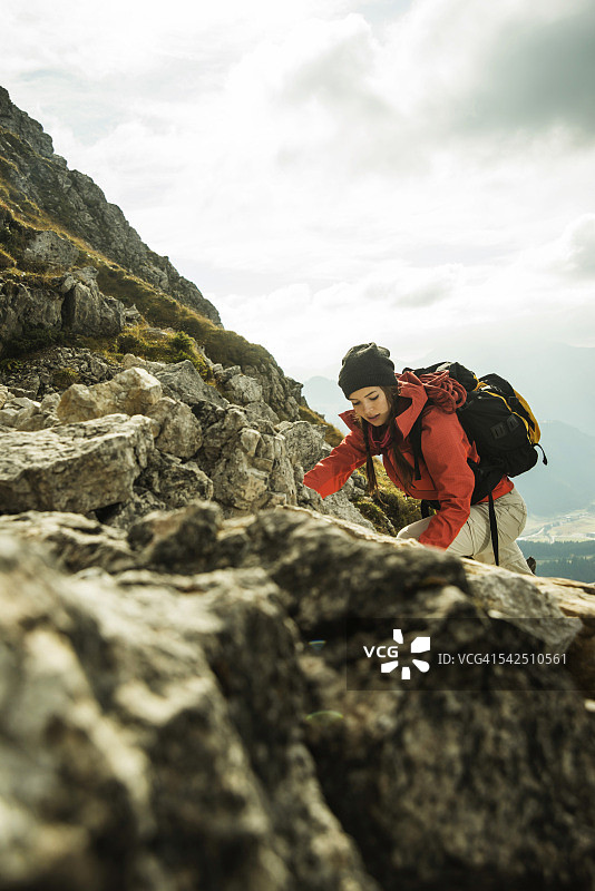 奥地利，蒂罗尔，坦海默塔尔，年轻女子在岩石上攀爬图片素材
