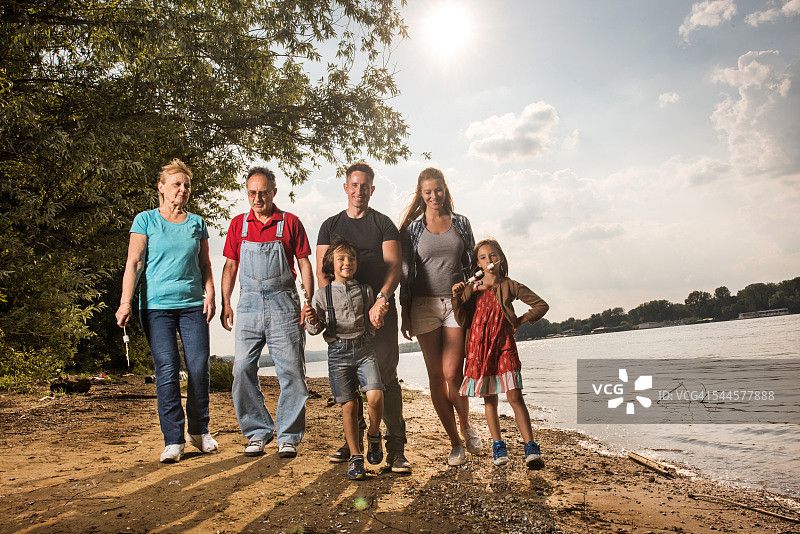 幸福的大家庭在河边散步。图片素材