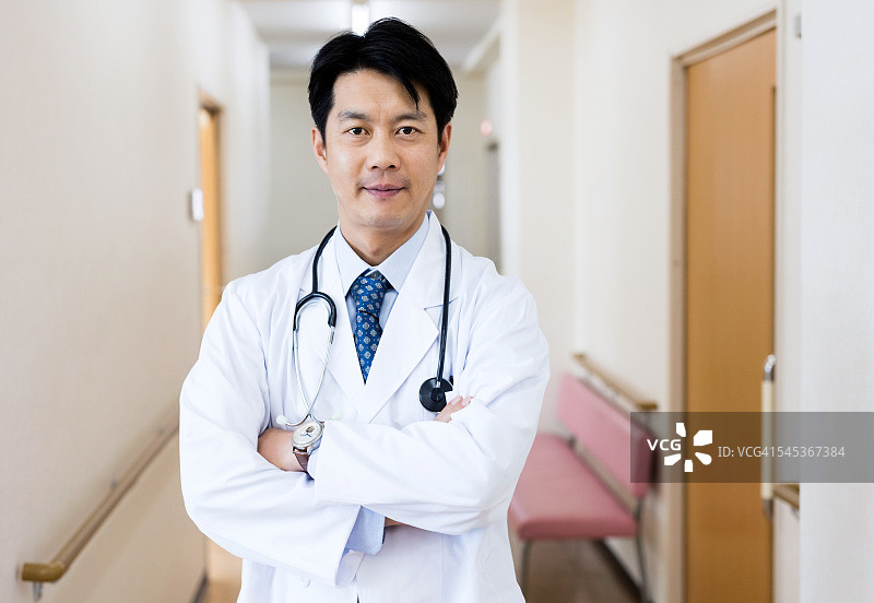 一个自信的日本医生站在走廊里图片素材