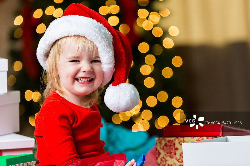 快乐的小女孩戴着圣诞帽在圣诞节图片素材